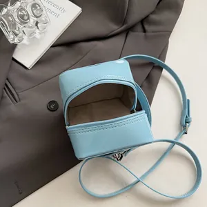 Minimalist light blue patent leather box bag with zipper closure and thin strap