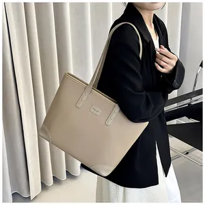 Close-up of beige tote bag featuring litchi texture leather and stylish shoulder straps