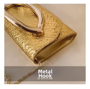 Detail shot of the shiny gold snake texture leather bag with robust U-shaped metal handle