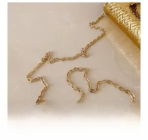 Close-up of golden metal chain and woven texture detail on elegant crossbody bag