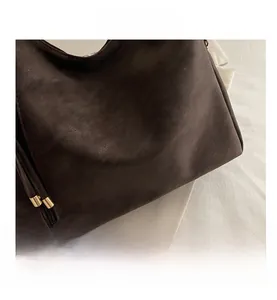 Macro view of dark brown leather texture with golden brand logo and zipper detail