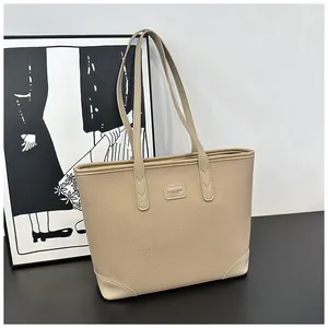 Close-up of the beige lychee pattern leather texture and reinforced corners of the tote bag