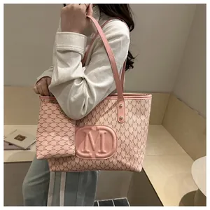 Detail of pink monogram tote bag with matching pouch shown on a fashion model