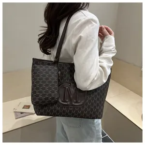 Detail of dark coffee tote bag with M-letter monogram print and hanging small coin purse