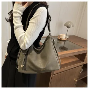 Close-up of olive green matte leather hobo bag with gold stamping and zipper details