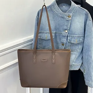 Brown lychee texture large capacity tote bag shown against a blue denim background