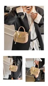 Détails du sac selle en paille tressée avec dentelle perlée et boucle en métal doré