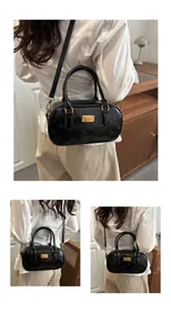 Primer plano de bolso negro con patrones de gato en relieve y placa dorada de lujo