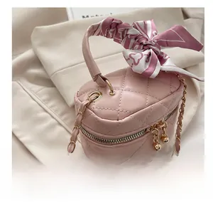 Detailed close-up of a pink quilted mini bag featuring golden hardware and silk scarf wrap