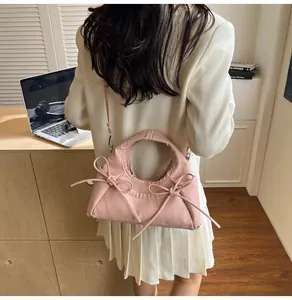 Detail of pink bow-knot tote bag shown from behind on a model in an office setting