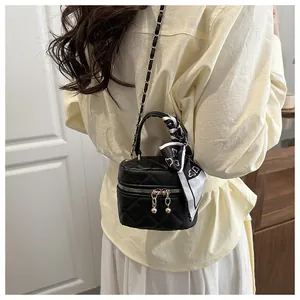Detailed back view of a mini black quilted bag with silk scarf handle and chain strap