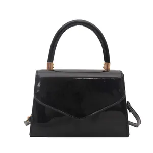 Sac à main élégant en cuir verni noir avec détails dorés et rabat en V pour femmes
