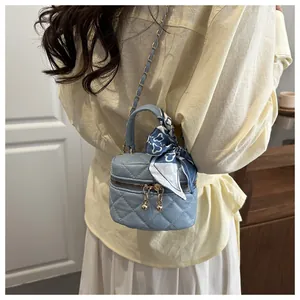 Close-up of mini blue quilted bag featuring gold chain strap and floral silk scarf detail