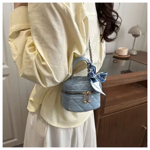 Detail of mini light blue quilted crossbody bag with floral scarf handle and chain strap