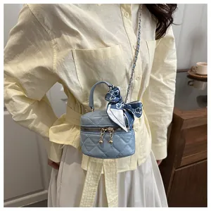 Mini blue quilted leather cylinder bag with gold ball zipper and scarf detail