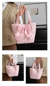 Detail of pink canvas tote featuring silk bow decoration and silver star patterns