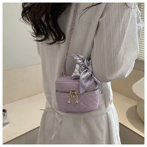 Detailed back view of a lavender quilted mini bag with a silk scarf and metal chain