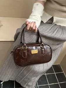 Bolso bowling de cuero marrón con grabados de gatos y placa metálica dorada