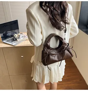 Detailed view of dark brown PU leather tote with stylish bow drawstrings on a female model