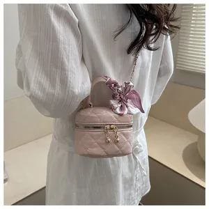 Pink quilted mini vanity bag with golden ball zipper and silk scarf handle detail