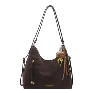 Dark brown high capacity shoulder tote bag with bear charm and tassel details