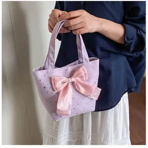 Detail of lavender tote bag featuring a large pink bow and silver glitter star patterns