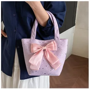 Detail view of large lavender canvas tote bag with pink satin star bow and carry handles