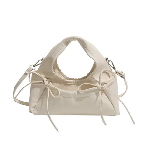 Minimalist cream white PU leather tote bag with elegant bow accents and silver hardware