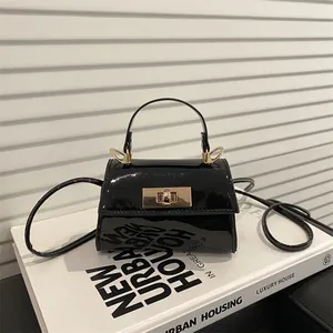 Elegant black patent leather mini handbag with gold metal clasp and top handle