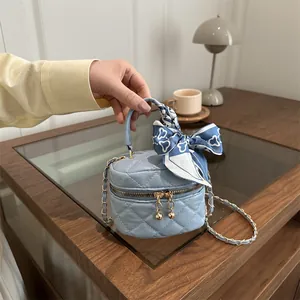 Mini light blue quilted crossbody bag with golden chain and decorative silk scarf