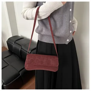 Close-up of a burgundy shoulder bag with leopard embossed texture on matte fabric
