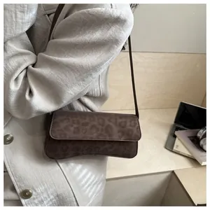 Brown leopard print shoulder bag in faux suede shown in a minimalist office setting