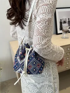 Ethnic geometric pattern woven bucket bag with white leather drawstring and thin strap