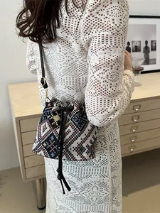 Ethnic style drawstring bucket bag with colorful geometric patterns and leather strap