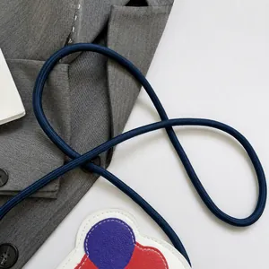 Detalle de cómoda correa tejida azul oscuro en un mini bolso bandolera colorido para niños