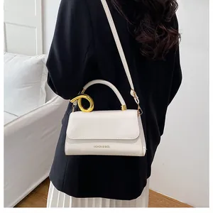 Detailed view of white PU leather crossbody bag with a golden twisted metal ring handle