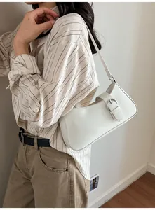 Detail shot of the white shoulder bag featuring a large silver buckle and PU leather texture
