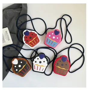 Detalle de bolsos bandolera infantiles con forma de cupcake coloridos en cuero sintético