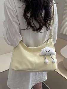 Minimalist cream shoulder bag with plush cloud charm and elegant vertical stitching