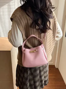 Pink lychee texture bucket bag with gold clasp shown on a model in a cozy interior