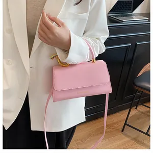 Fashionable pink leather handbag detail featuring a modern golden metal circular handle