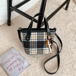 Vintage plaid tote bag with wooden bead pendant and detachable shoulder strap on plush rug