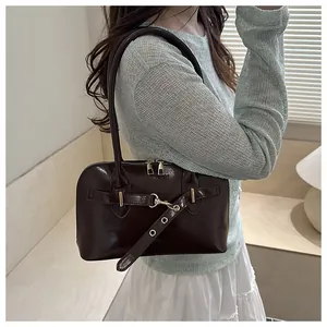 Detail der dunkelbraunen, glänzenden Muscheltasche aus Leder mit Metallschnalle