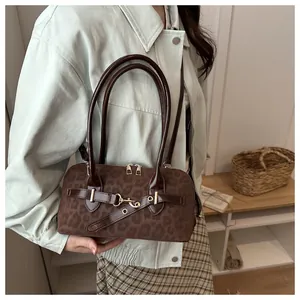 Detail der Vintage-Schultertasche mit Leopardenmuster, goldener Schnalle und Wildlederstruktur