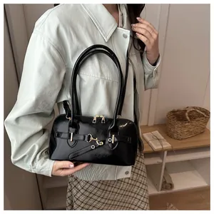 Detail der glänzenden schwarzen Lackledertasche mit edler goldener Metallschnalle und Dekor