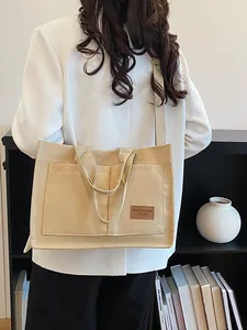 Women's beige large canvas tote bag with shoulder strap and front pockets for daily commute