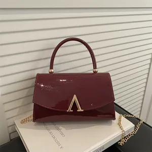 Sac à bandoulière minimaliste en cuir verni bordeaux avec fermoir en V doré
