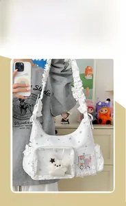 Mädchen mit weißer Ita-Bag mit Sternmuster, Klarsichtfach und Rüschen-Schultergurt
