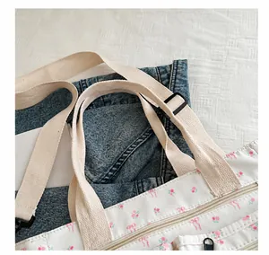 Detail van de bloemen canvas tas met verstelbare geweven schouderriem en ritssluiting