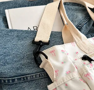 Detailweergave van de bloemen shopper met afneembare haak en geweven schouderband